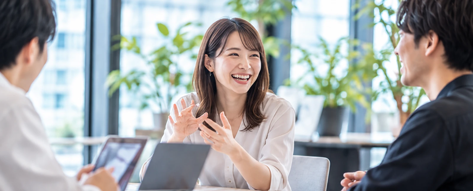 明るいオフィスで生き生きと語り合うチーム