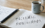 コーヒーとペン、手書きメッセージのある開かれた手帳